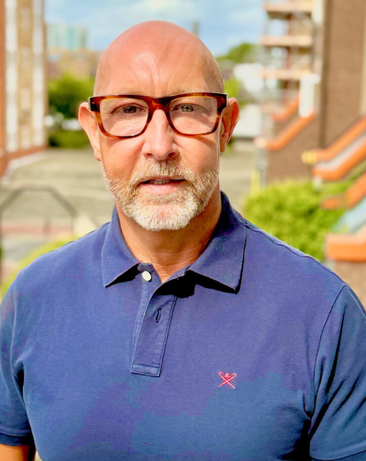 Portrait of John Butt wearing a blue polo shirt